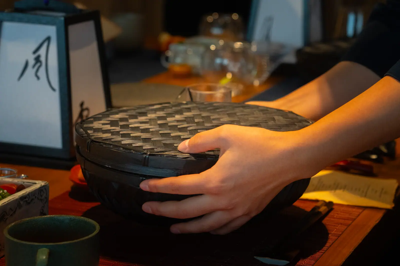 A dining attendant presenting a traditional woven serving basket